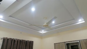 A room with a ceiling fan, recessed lighting, a curtain, and a cabinet. - Navid’s Holiday Resort and Hotel, Murree – Spacious Three-Bedroom Apartment (Ghora Gali)