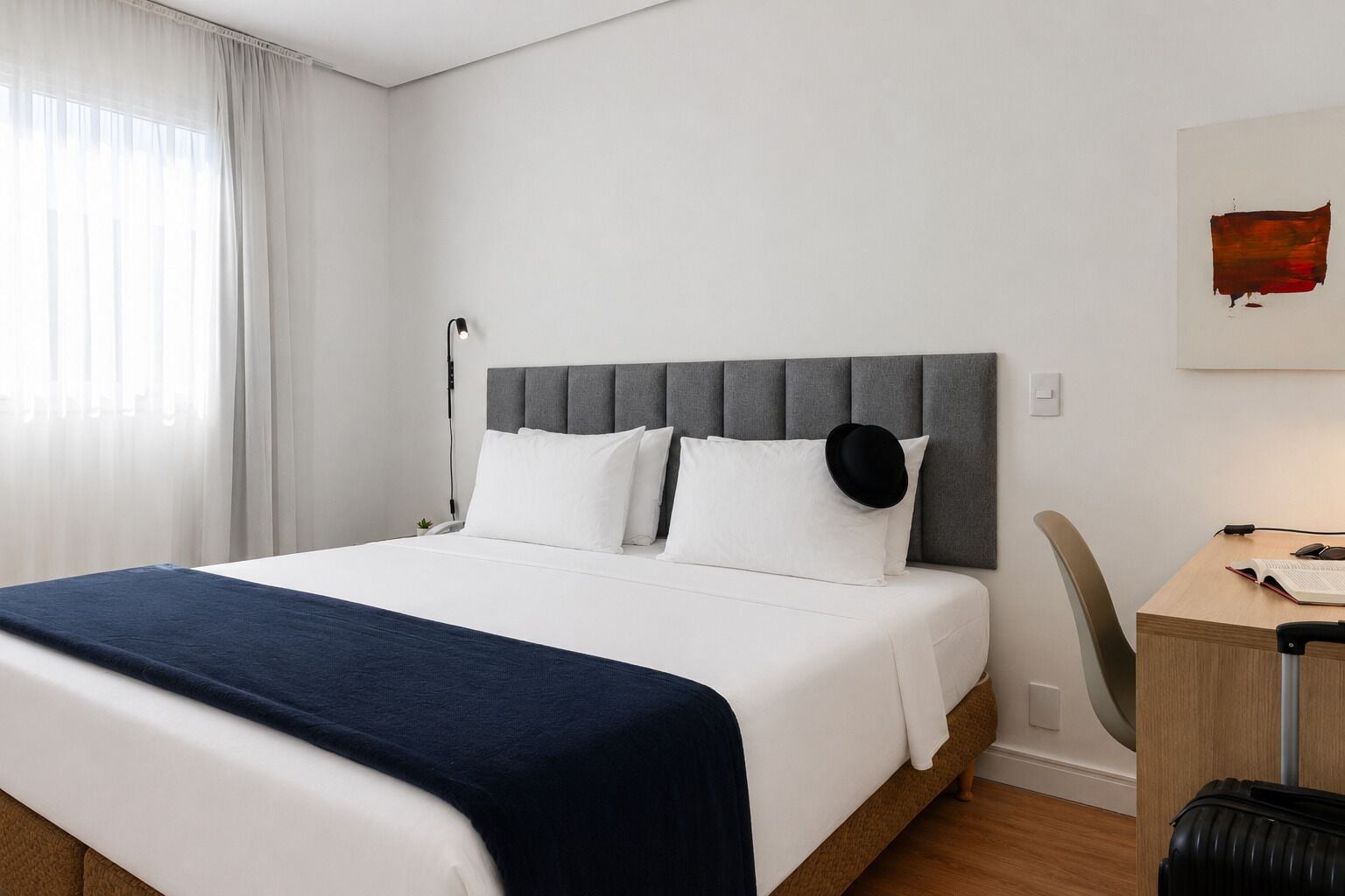 Una habitación de hotel con una cama, un escritorio y una silla.