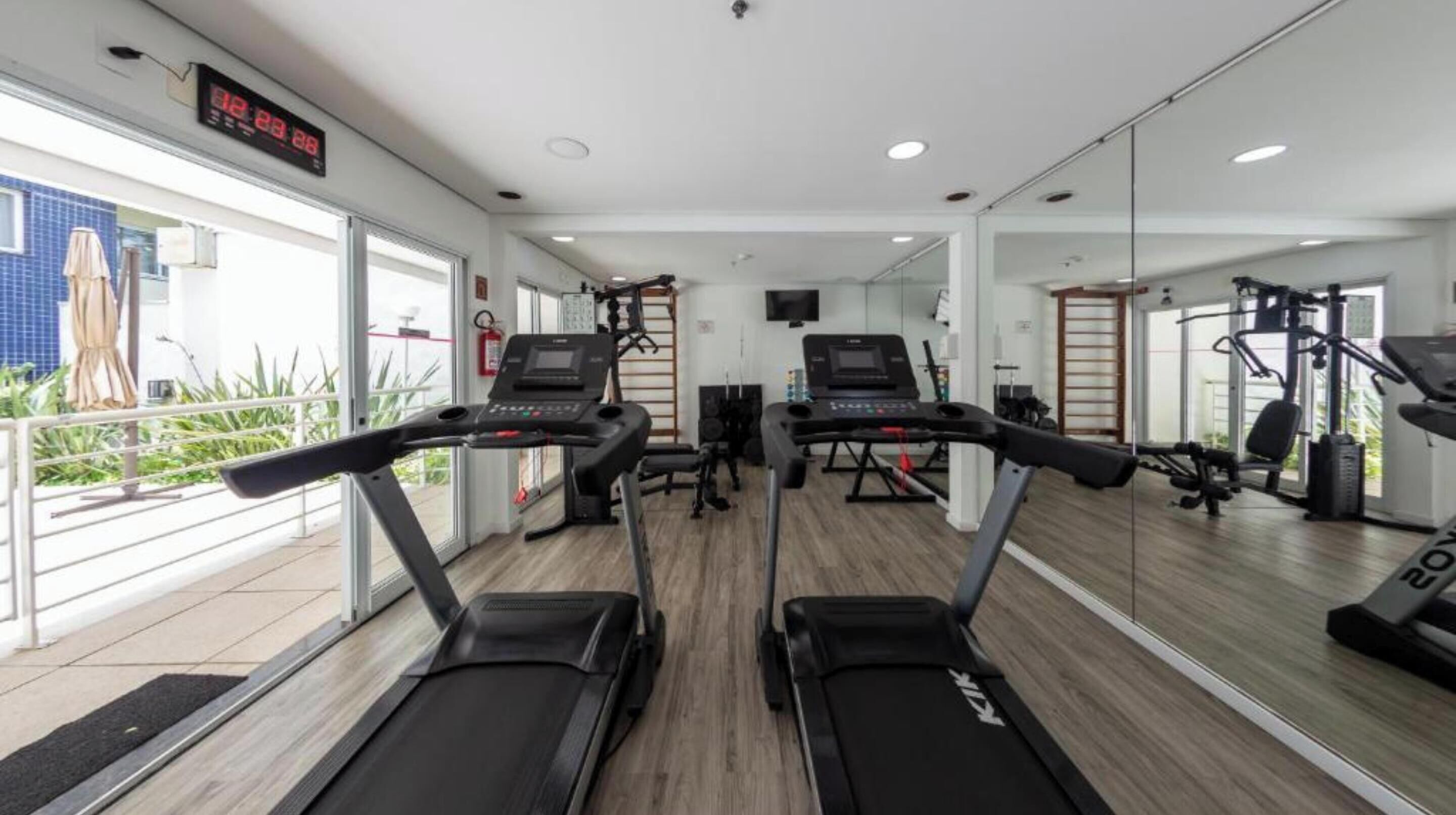 Une salle de sport équipée de tapis de course, de vélos d’exercice et d’appareils de musculation.