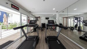A gym with treadmills, exercise bikes, and weight machines. - St. Charbel by Charlie (São Paulo)