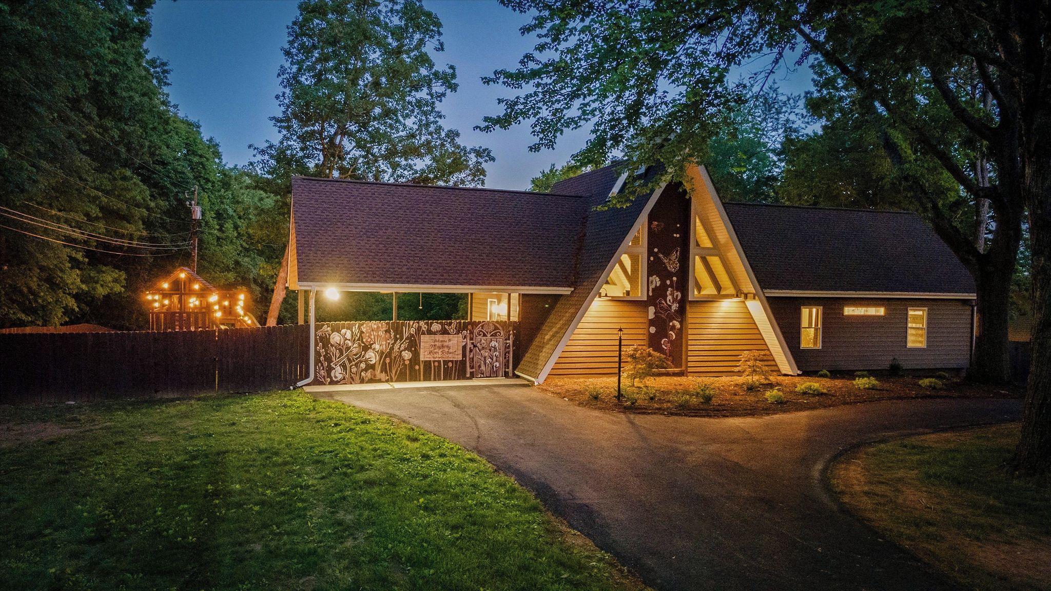 A house with a sloped roof, a front porch, and a fenced yard.