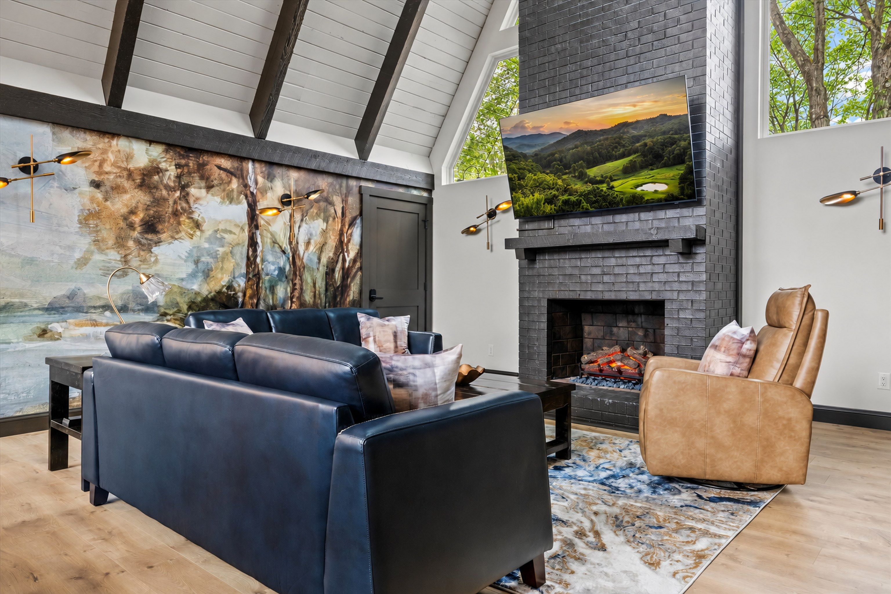 A modern living room with a fireplace, leather sofas, and a large TV mounted on the wall.