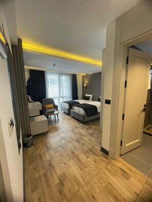 A hotel room with a bed, a desk, a chair, and a small table. - ck otel (Sarikamis)