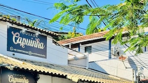 Un bâtiment sur lequel on peut lire l’inscription « Pousada Capinha », avec une rue pavée devant.