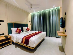Ein Hotelzimmer mit einem Bett, einem Nachttisch und einem an der Wand befestigten Fernseher.
