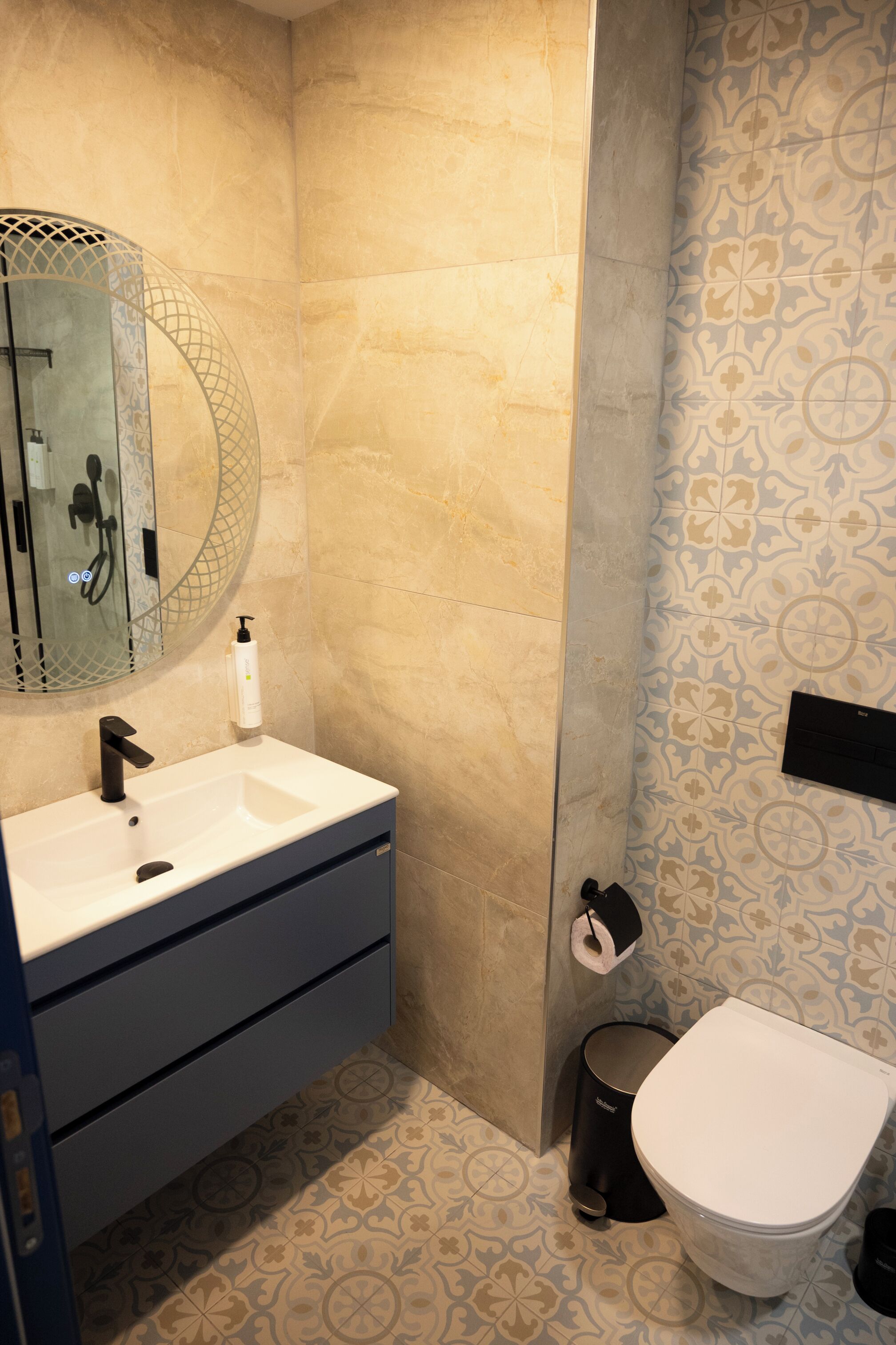 A bathroom with a white sink, black faucet, and a toilet.