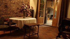 Un comedor con una mesa redonda, sillas y un jarrón de flores.