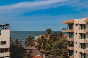 A beachfront hotel with multiple floors, balconies, and a view of the ocean. - Vista Verde: Rooftop pool, pets, and near beach (San Pancho)