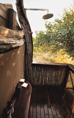 A wooden deck with a built-in shower, surrounded by trees. - Mozhi Bushcamp  (Kafue National Park)