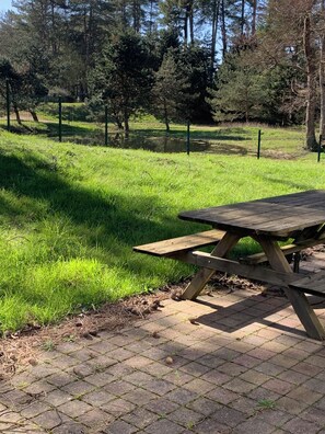 A picnic table in a park with a grassy area and trees in the background. - Villa "Parfum de dunes", Domaine du golf des Pins, Hardelot, along the golf course. (Neufchâtel-Hardelot)