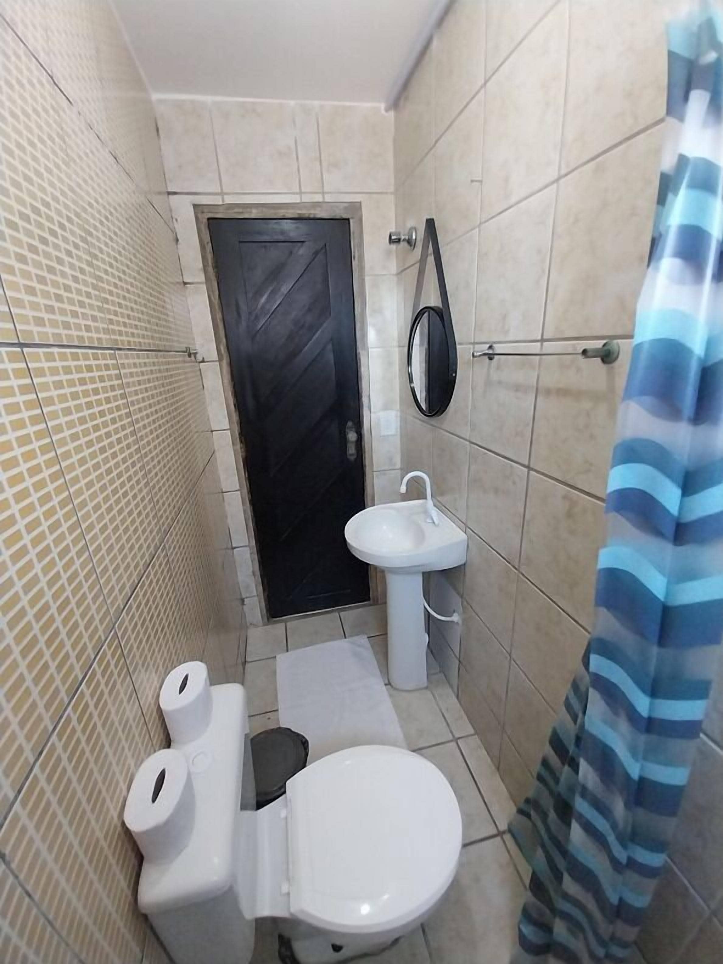 Un baño pequeño con inodoro, lavabo y espejo.
