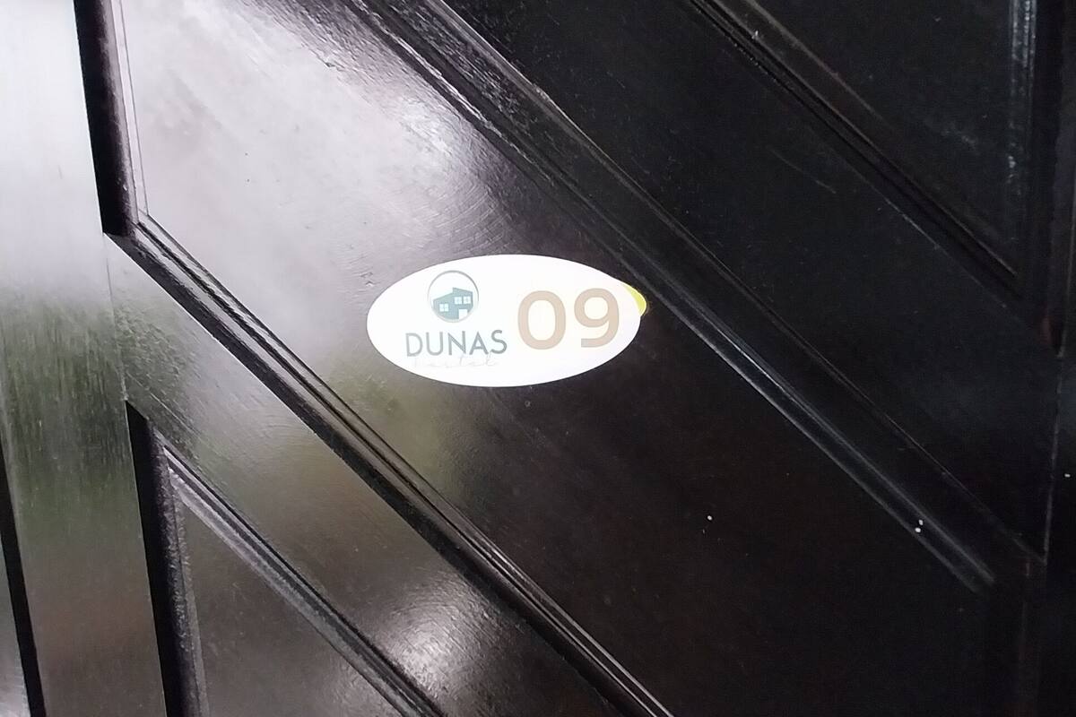 A black door with a white sticker that reads "DUNAS 09".