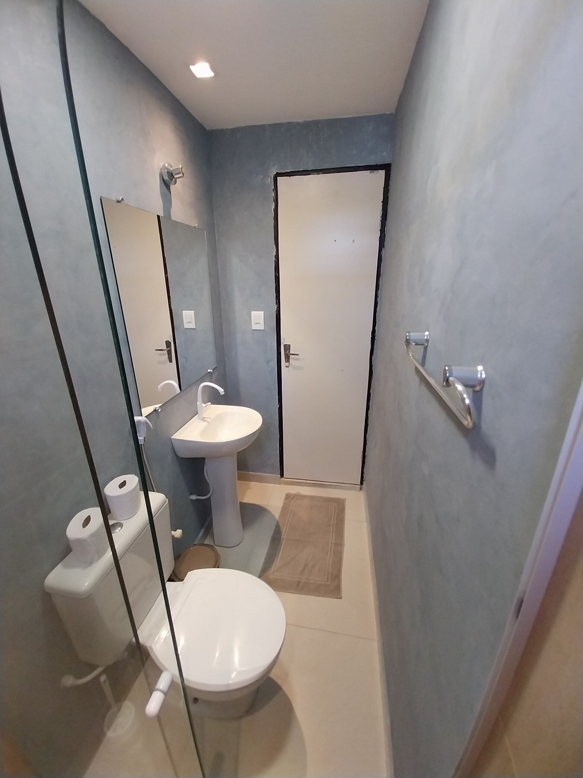 A small bathroom with a toilet, sink, and mirror.