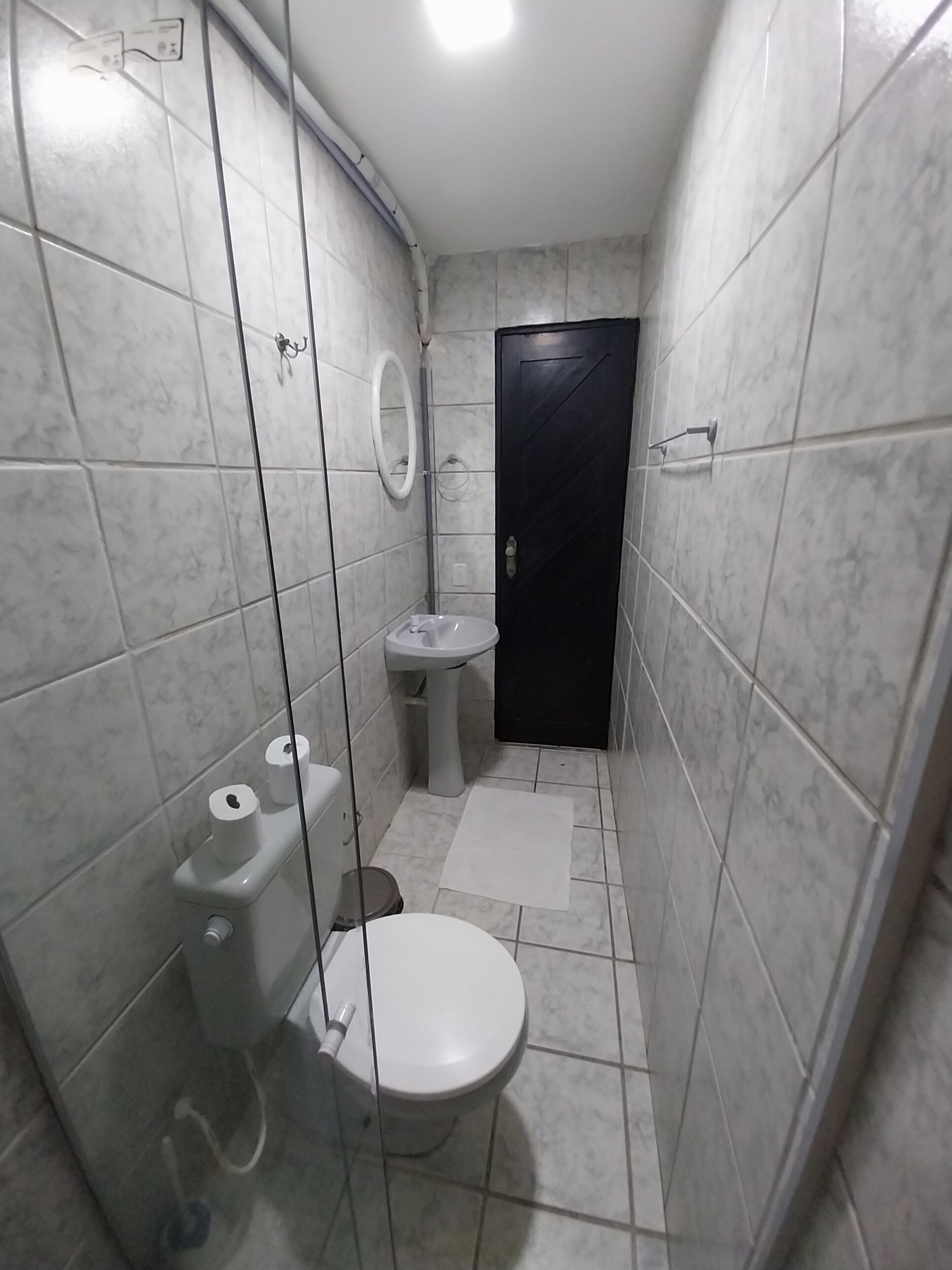 Ein kleines Badezimmer mit Toilette, Waschbecken und Dusche.