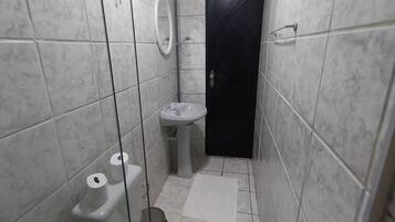 Ein kleines Badezimmer mit Toilette, Waschbecken und Dusche.