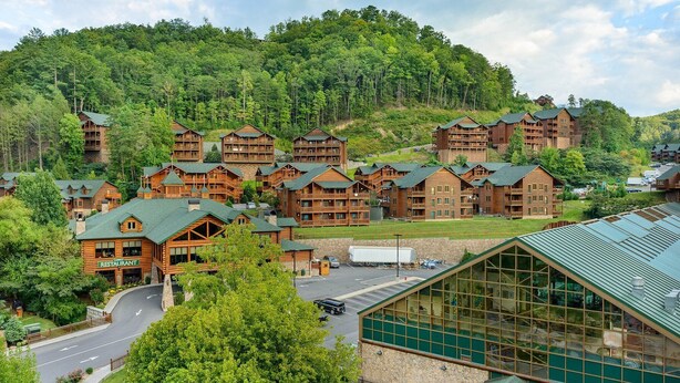A lodge with multiple wooden buildings, a restaurant, and a parking area.