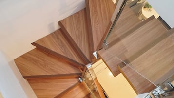 Una escalera de caracol con escalones de madera y barandilla de vidrio.