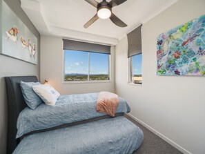 A bedroom with a bed, a ceiling fan, a window with a view, and a painting on the wall. - Aurora Pacific U12 Walk To Kings Beach & Shops (Kings Beach)
