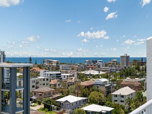 A residential area with various building types, including modern and traditional architecture, and a clear view of the sea in the background. - Aurora Pacific U12 Walk To Kings Beach & Shops (Kings Beach)