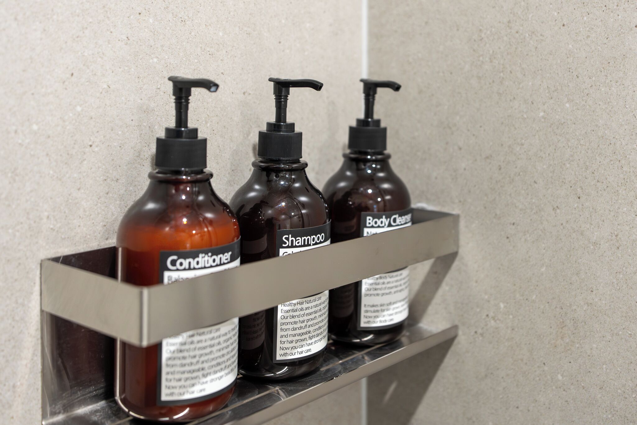 Three bottles of hair care products on a shelf.