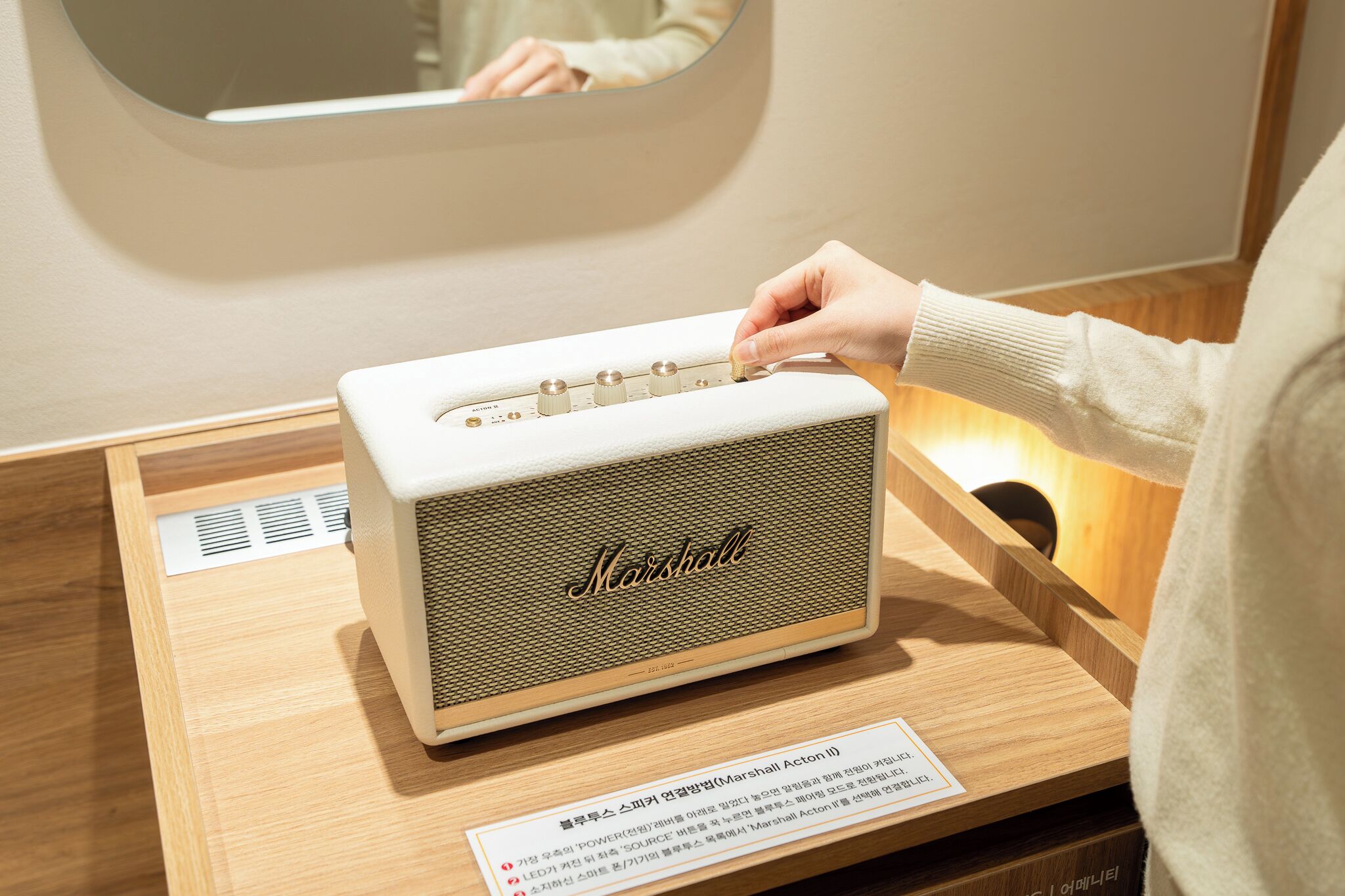Ein Vintage-Marshall-Verstärker auf Podest, mit Holzfuß und einem Etikett in einer Fremdsprache.