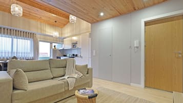 Leilighet – deluxe | Oppholdsområde | En 55-tommers smart-TV med kabel-kanaler