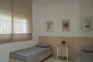Ein Schlafzimmer mit einem Einzelbett, einem Nachttisch und drei gerahmten Bildern an der Wand.