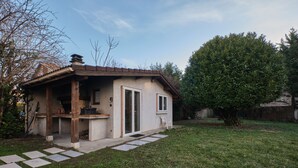 A house with a patio, a door, and a small garden. - Cosy Cabin “Cabane Grenobloise” with Shared Garden (Eybens)