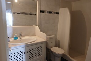 A bathroom with a white sink, toilet, and shower. - DIAMOND on the cliff Hotel &Suites (Santorini)
