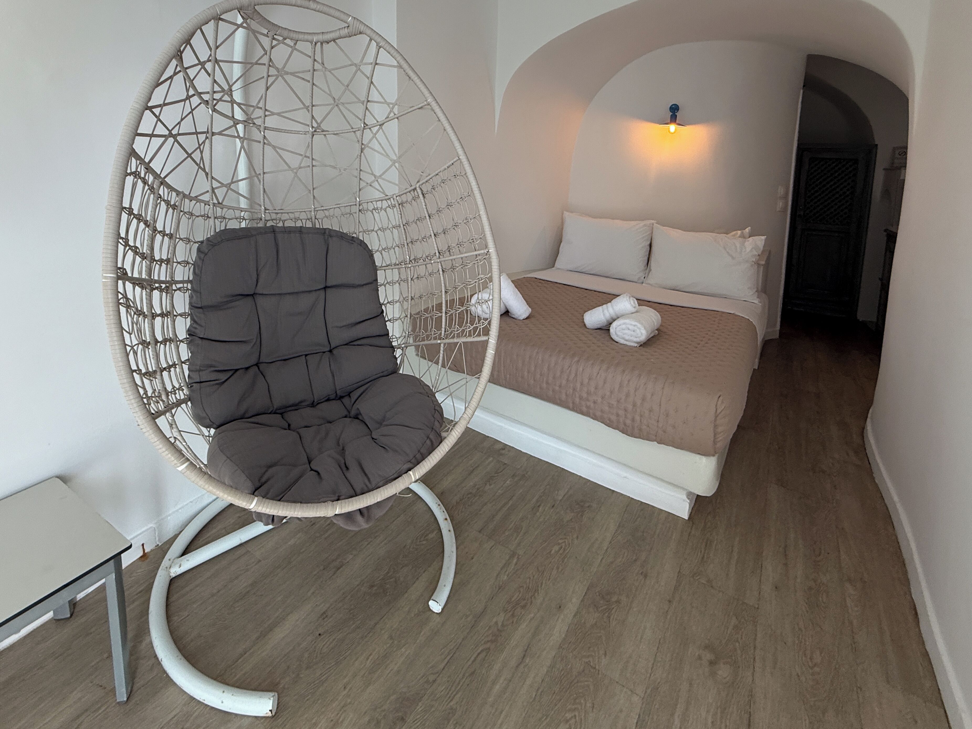 Ein Zimmer mit einem Bett, einem Hängesessel und einem kleinen Tisch.