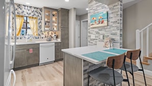 Una cocina moderna con una isla central, armarios de madera y salpicadero de azulejos.