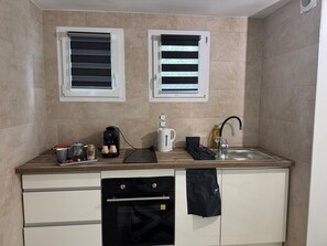 Een koelkast, een oven, een kookplaat, een koffiezetapparaat/waterkoker