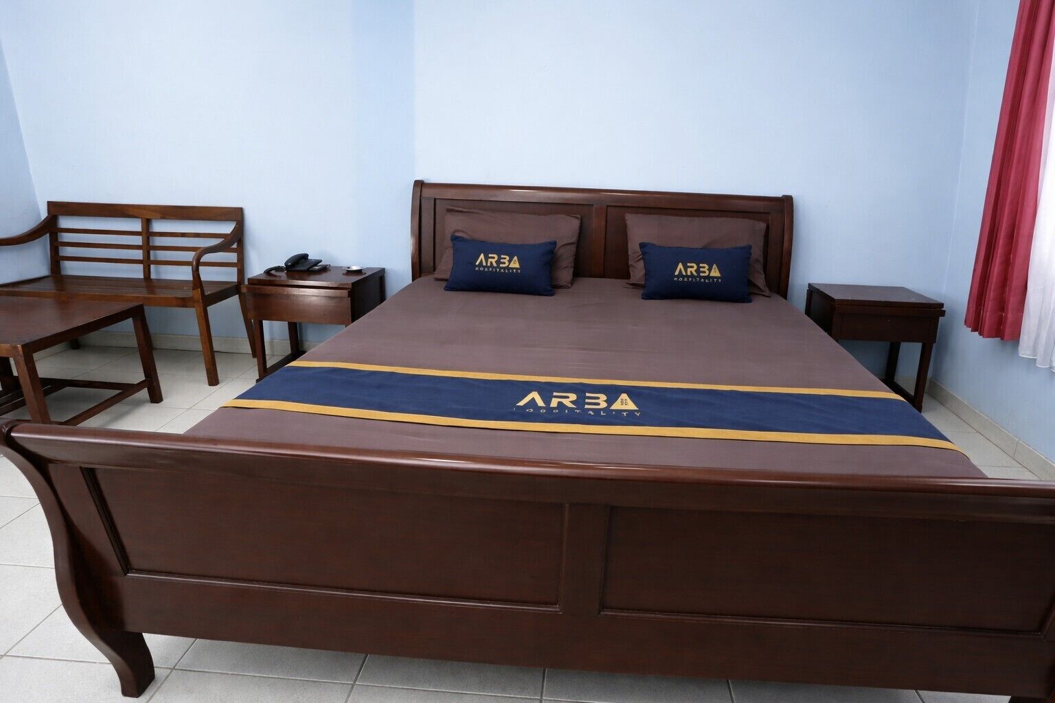 Une chambre à coucher avec un grand lit, deux oreillers, une table de chevet, une chaise et un bureau.