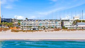 A beachfront hotel with multiple balconies, a sandy beach, and ocean waves. - The Ambassador - Unit C5 - Studio King - On Pool Deck (Panama City Beach)
