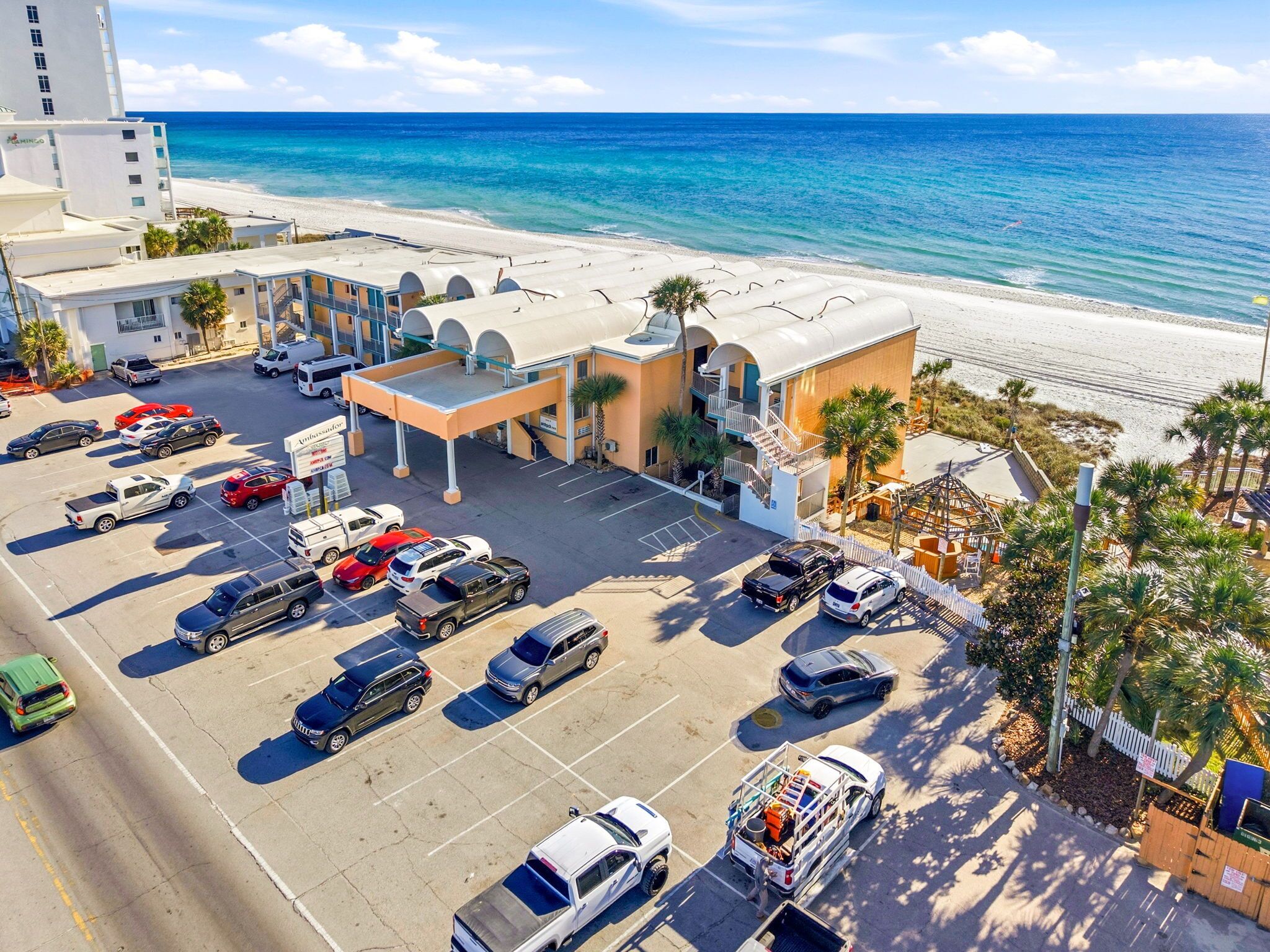 Un hôtel doté d’un parking, offrant une vue sur la plage, et dont le bâtiment présente une façade incurvée.