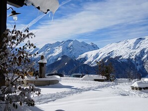 A snowy mountain landscape with a clear sky, a stone structure, and parked cars. - Apartment “Les Granges 13” with Mountain View, Balcony and Wi-Fi (Villard-Reculas)