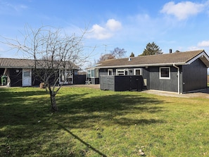 Ein Wohngebiet mit einem Haus, einer Garage, einem Geräteschuppen und einem Rasen.