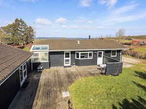 Ein zweistöckiges Haus mit Terrasse, Garage und Meerblick.