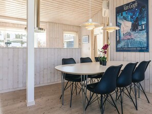 A dining area with a round table, black chairs, pendant lights, and a Van Gogh painting. - 4 Star Holiday Home in Svendborg (Svendborg)