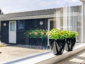 Two potted plants on a windowsill with a view of a building in the background. - 4 Star Holiday Home in Svendborg (Svendborg)