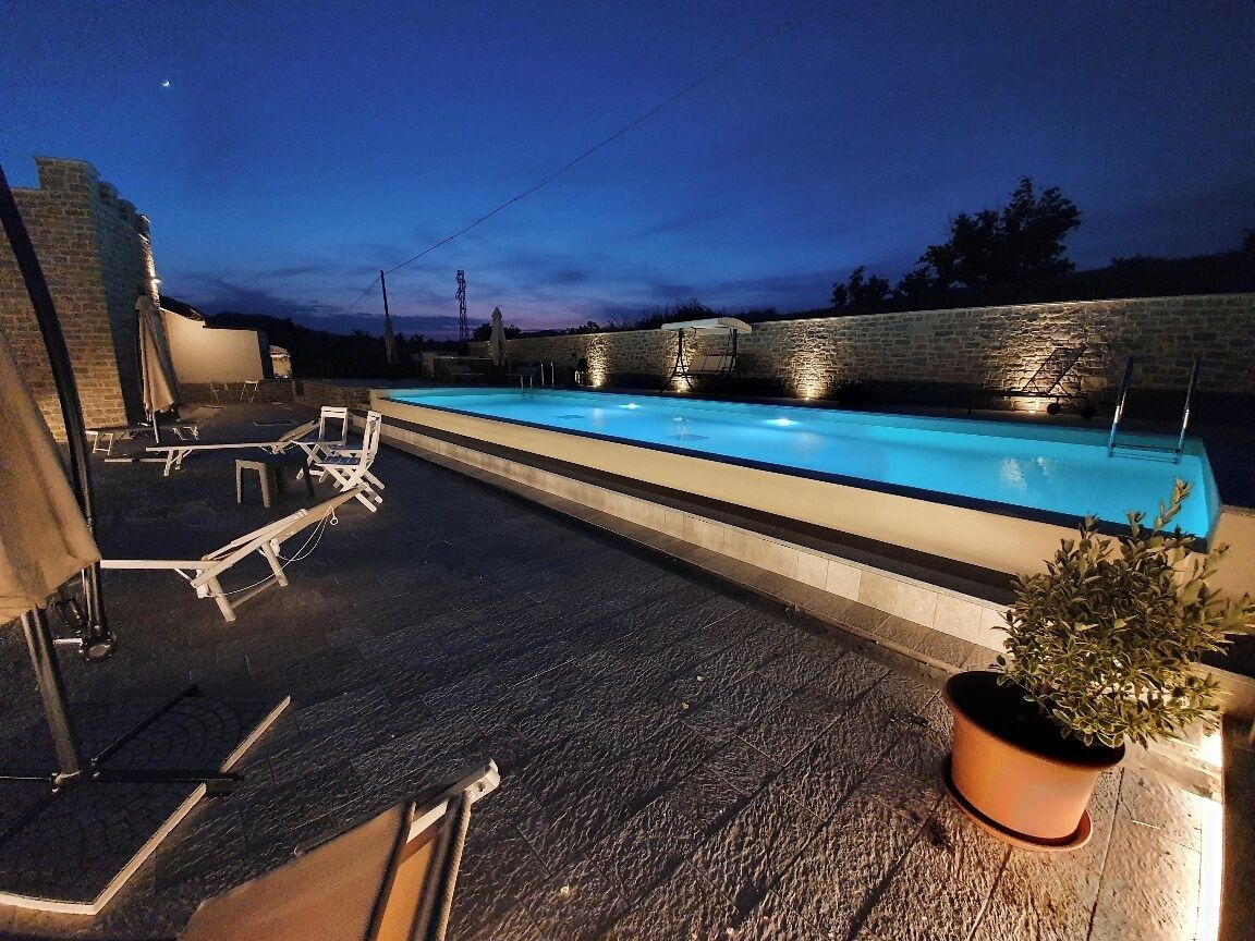 En säsongsöppen utomhuspool, parasoller och solstolar