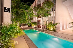 A swimming pool with surrounding greenery and a building with a visible 'A' sign. - Work & Relax apto fast wifi (Tulum)