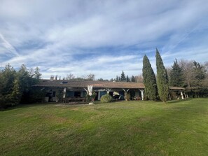 A house with a tiled roof, a covered porch, and a well-maintained lawn. - Le Marais de Capeau, private with pond, swimming pool and leisure facilities (Arles)