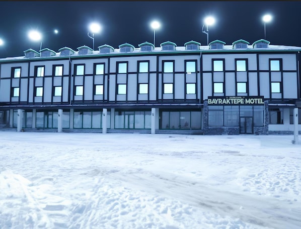 A motel with multiple windows and a sign that reads "Bayraktepe Motel".