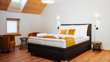 Een moderne slaapkamer met een groot bed, twee nachtkastjes, een bureau en een stoel.