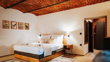 A bedroom with a wooden bed, a brick ceiling, and a small side table.