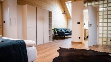 A modern interior with a wooden ceiling, a large window, and a sofa in the background.