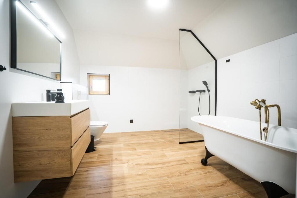 Une salle de bain moderne avec un meuble-lavabo en bois, une baignoire blanche et une cabine de douche en verre.