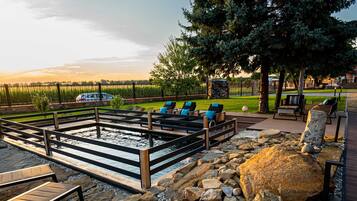 An outdoor patio area with a pool, lounge chairs, and a stone pathway.