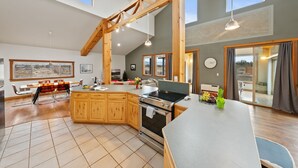 Una cocina amplia con armarios de madera, una isla central y un ventanal grande.
